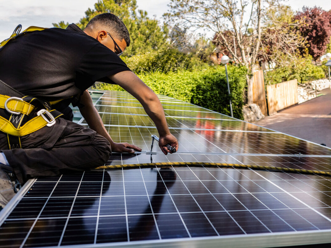 Man of a roof installing solar panels.