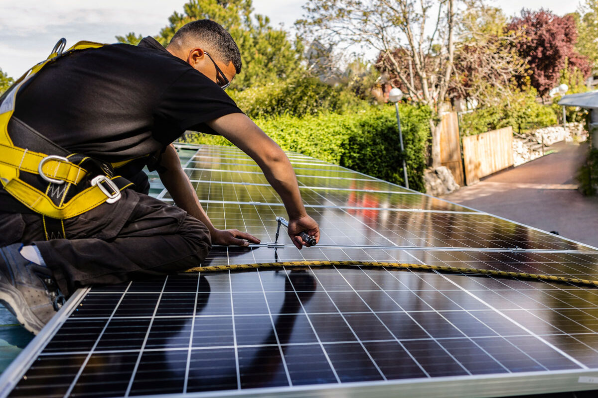 Man of a roof installing solar panels.